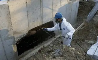 Professional waterproofing the exterior walls of the basement in Des Moines, IA